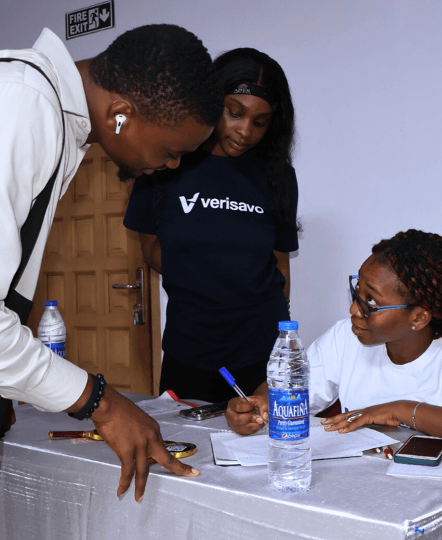 Group of people standing around a display of video screens